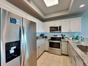 a kitchen with white cabinets and a stainless steel refrigerator at The Indies #209 in Fort Morgan +48 photos