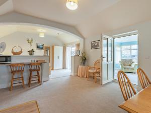 a kitchen and living room with a table and chairs at The Saddlery - Uk36123 in Horsington