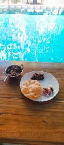 a plate of food on a table next to a pool at Bonsaiyog in Chapora