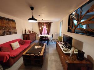 a living room with a couch and a table at Chambre privée avec Jardin in Les Ulis