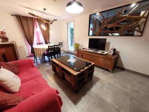 a living room with a red couch and a table at Chambre privée avec Jardin in Les Ulis