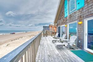 a wooden deck with chairs and a building on the beach at AV175 Sandfiddler 175 in Avon