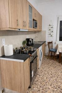 a kitchen with wooden cabinets and a stove top oven at Mytilene Heritage Loft 3A2 in Mytilene
