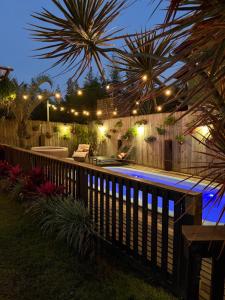 a backyard with a swimming pool at night with lights at Studios Malakoopa - Praia do Rosa in Praia do Rosa