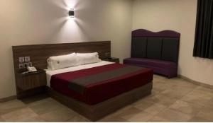 a bedroom with a large bed and a purple chair at Tulamor Love Suites & Villas in San Lorenzo