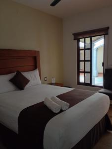 a bedroom with a large bed with two towels on it at Hotel RINCON RESORT TEQUILA in Tequila