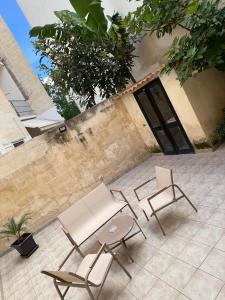 a patio with two chairs and a table and chairs at WHITEHOUSE in Lecce