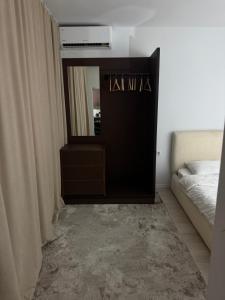 a bedroom with a dresser and a mirror and a bed at Deluxe Apartment 1 in Gnjilane