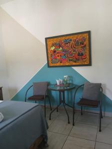 ein Zimmer mit einem Tisch, zwei Stühlen und einem Gemälde in der Unterkunft Casa Solares in Atlixco