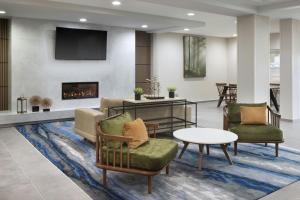 a living room with two chairs and a fireplace at Fairfield Inn & Suites Lake City in Lake City