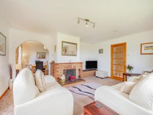 a living room with two white couches and a fireplace at Glenview in Appin