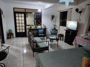 a living room with a couch and a tv at Pousada Vento Leste in Cabo Frio