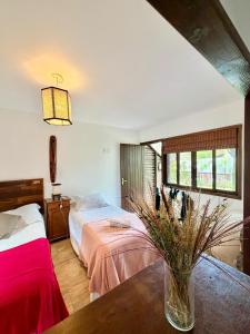 a bedroom with a bed and a vase on a table at Studios Malakoopa - Praia do Rosa in Praia do Rosa +108 photos