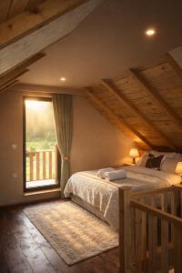 a bedroom with a bed and a large window at Adria Nord Chalets in Žabljak