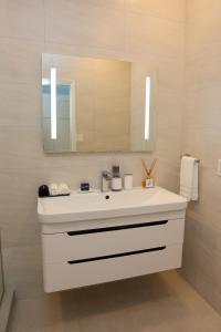 a bathroom with a white sink and a mirror at 232C South Finger in Jolly Harbour +8 photos