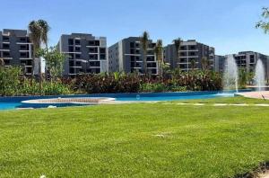 a park with a fountain in front of some buildings at Sun capital stylish apartment in ‘Ezbet `Abd el-Ḥamîd