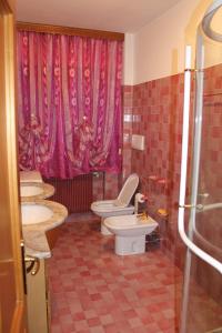 ein Badezimmer mit 3 Waschbecken und 2 WCs in der Unterkunft Patrick's House in Belluno