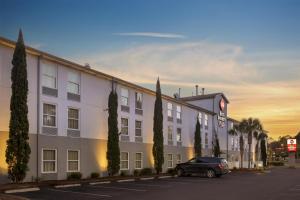 a building with a car parked in a parking lot at Best Western Plus Tallahassee North Hotel in Tallahassee