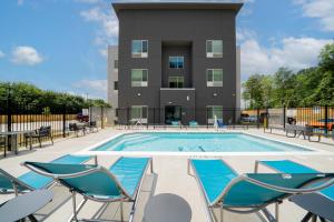 a pool with chairs and a building in the background at TownePlace Suites Longview in Longview