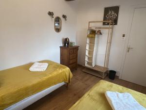 a bedroom with two beds and a dresser and a mirror at Au pré du puy in Chambretaud