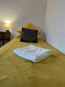 a white towel on a bed with a pillow at Au pré du puy in Chambretaud