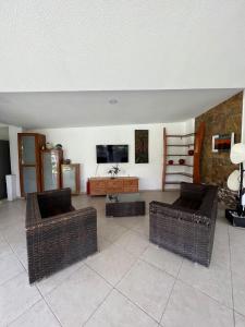 a living room with two wicker chairs and a television at Residencia privada de 10 habitaciones para 20 personas in Chiconcuac