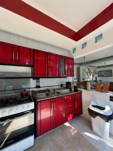 a kitchen with red cabinets and a red stripe on the ceiling at Residencia privada de 10 habitaciones para 20 personas in Chiconcuac