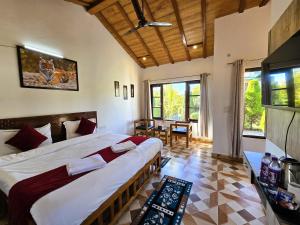 a bedroom with a large bed in a room at Corbett Mid Forest House - 1 Min Walk from Dabka River in Rāmnagar