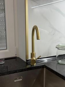 a kitchen sink with a gold faucet on a counter at Feeling Porto House in Porto