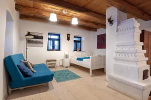 a living room with a bed and a blue couch at NohaTerény in Terény