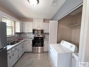 a kitchen with white cabinets and a stove top oven at 305 Calle Amistosa in Brownsville