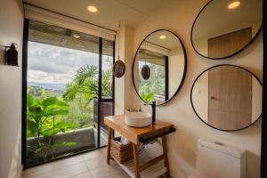a bathroom with a sink and two mirrors at Cannúa Lodge Hotel in Marinilla +46 photos