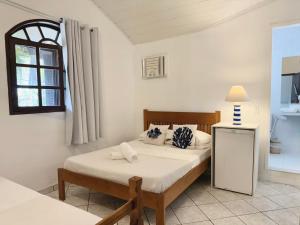 a bedroom with a bed and a window at Peixe Crew Rua das Pedras in Búzios