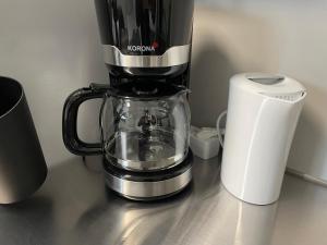 a coffee maker on a counter next to a roll of paper towels at Monteur Boardinghouse WorkHomes Zuffenhausen in Stuttgart