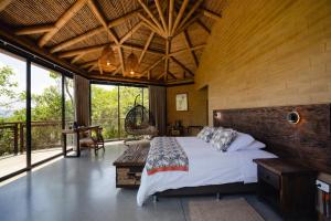 a bedroom with a large bed in a room with windows at Cannúa Lodge Hotel in Marinilla