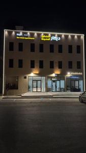 a building with a parking lot in front of it at night at ديار الاسترخاء للشقق المخدومة اقتصادي in Najran