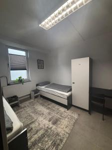 a bedroom with a bed and a white cabinet at Monteur Boardinghouse WorkHomes Zuffenhausen in Stuttgart