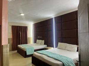 a room with two beds in a hotel room at DE-George's Grand Resort in Mama
