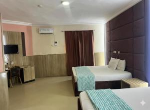 a hotel room with two beds and a tv at DE-George's Grand Resort in Mama