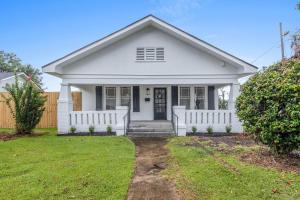 a white house with a white fence at The Lake Charles Charmer in Lake Charles