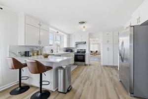 a kitchen with white cabinets and stainless steel appliances at The Lake Charles Charmer in Lake Charles
