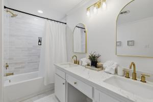 a white bathroom with two sinks and a tub and a shower at The Lake Charles Charmer in Lake Charles +13 photos