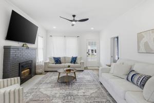 a living room with a couch and a fireplace at The Lake Charles Charmer in Lake Charles