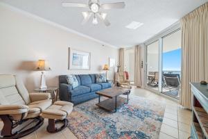 a living room with a blue couch and a table at Palacio Unit 403 in Pensacola +44 photos