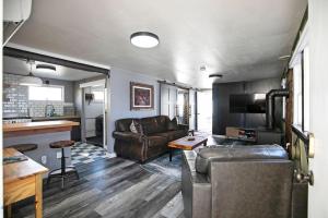 a living room with a leather couch and a kitchen at Rose Park Hideaway in Missoula