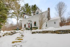 a white house with snow in front of it at Historic 1820s Homestead on Battenkill River! in Arlington
