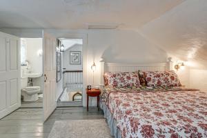 a bedroom with a bed and a bathroom with a sink at Historic 1820s Homestead on Battenkill River! in Arlington
