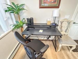a black desk with a chair and a computer at Gather Together home in Montrose