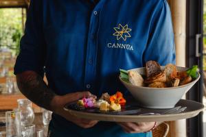 a man holding a tray of food on a plate at Cannúa Lodge Hotel in Marinilla
