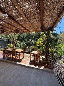a patio with a table and chairs under a wooden roof at Loft Amplio con Vista Natural en Mazunte in Mazunte +15 photos